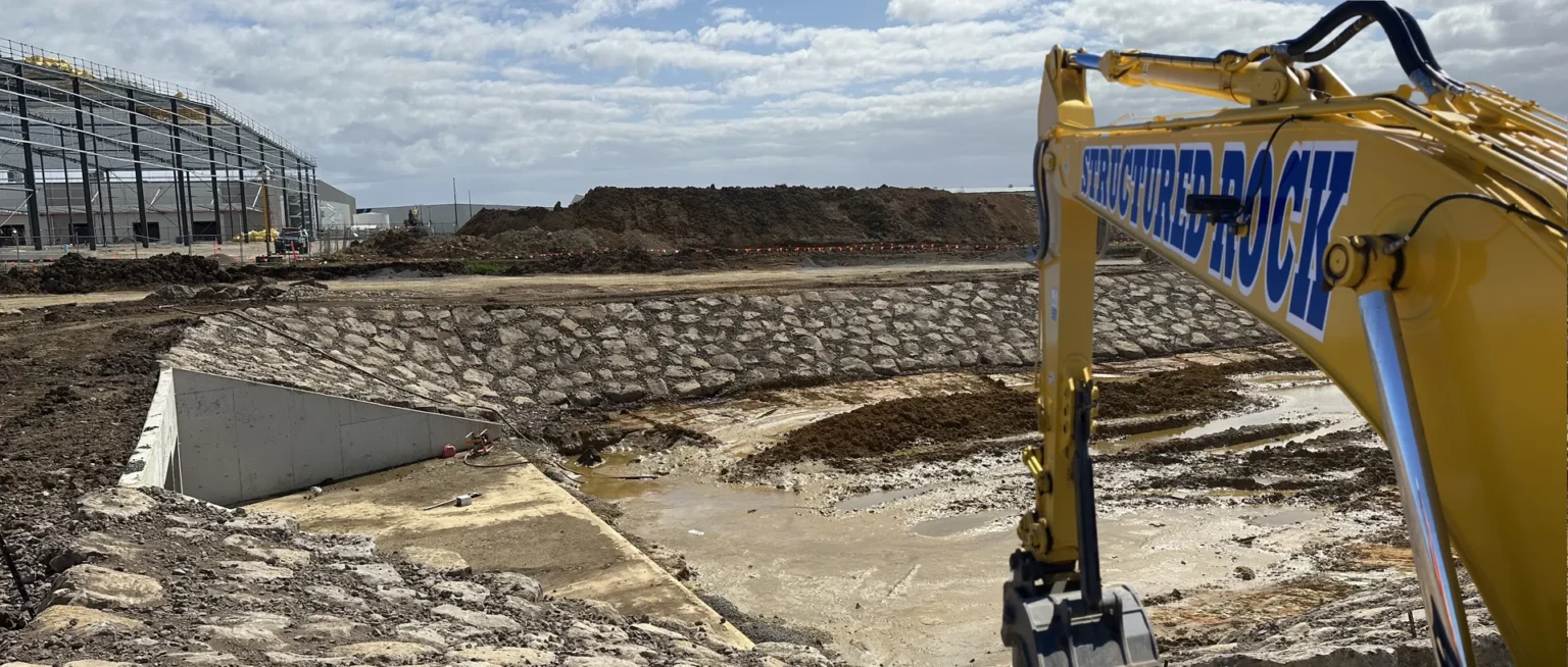 Excavator at a construction site with building framework